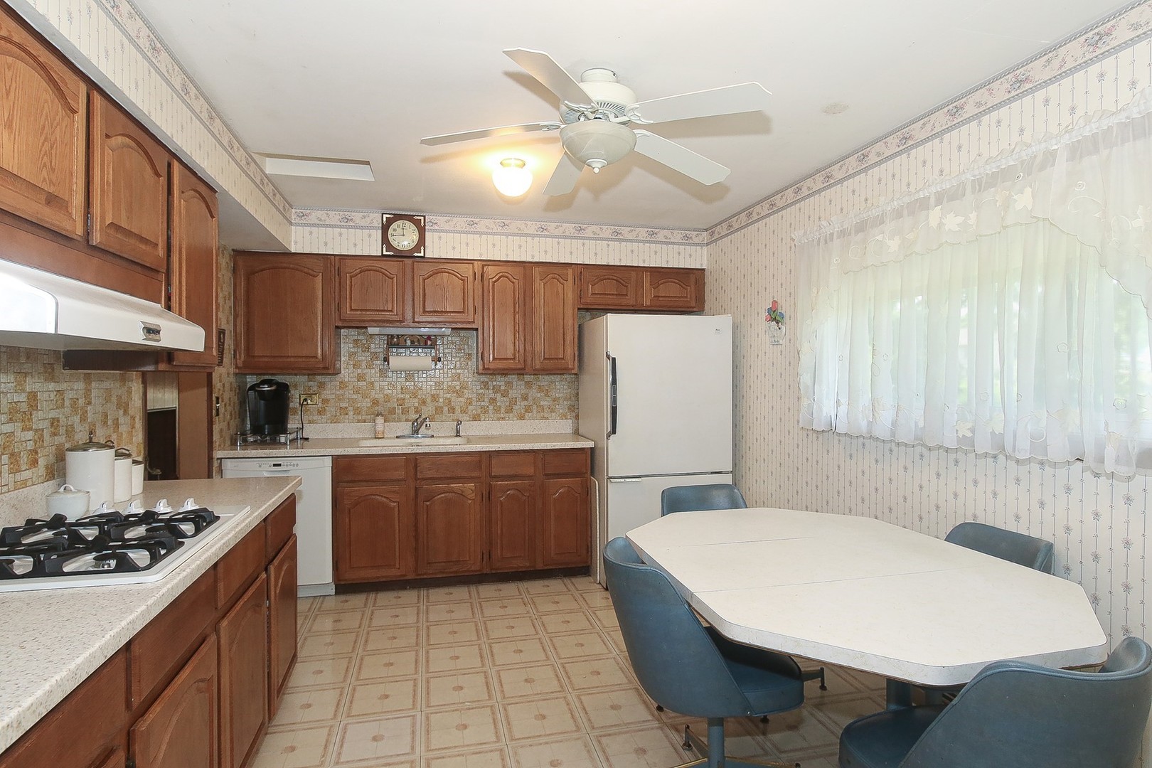 300 South We Go Trail Mount Prospect, IL 60056 - Photo 3 of 27 a kitchen with a table chairs stove a sink dishwasher and cabinets