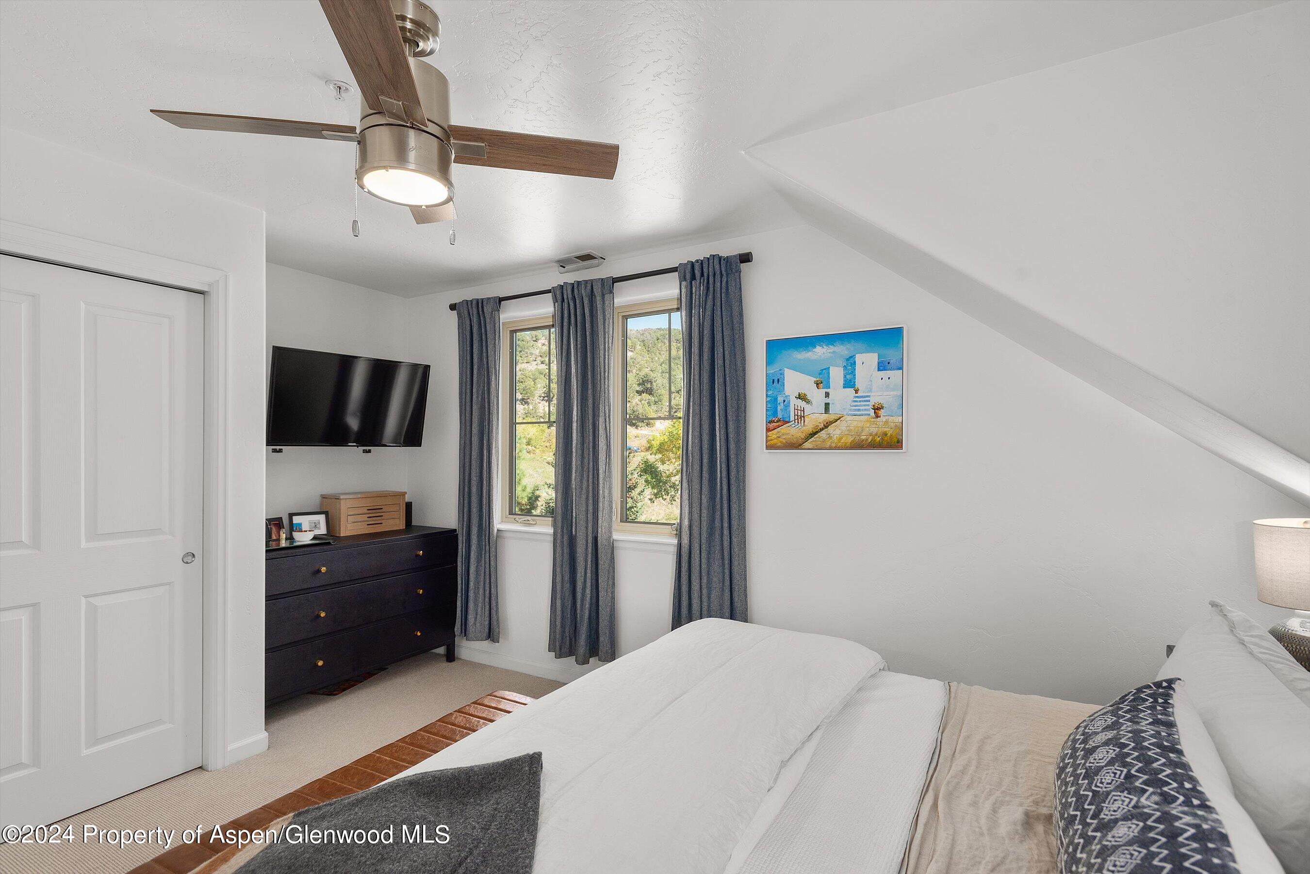 214 Lakeside Drive Basalt, CO 81621 - Photo 14 of 31 a bedroom with a bed and a flat tv screen on the dresser