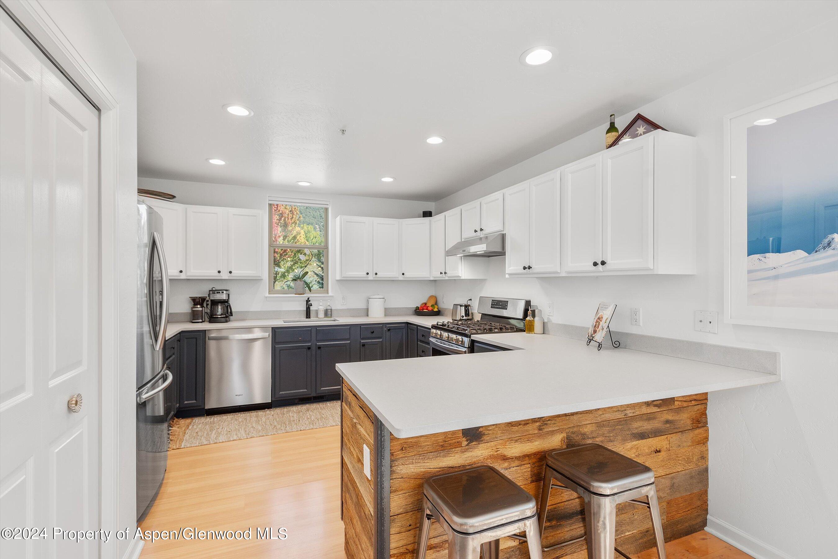 214 Lakeside Drive Basalt, CO 81621 - Photo 2 of 31 a kitchen with a sink a stove a refrigerator and white cabinets
