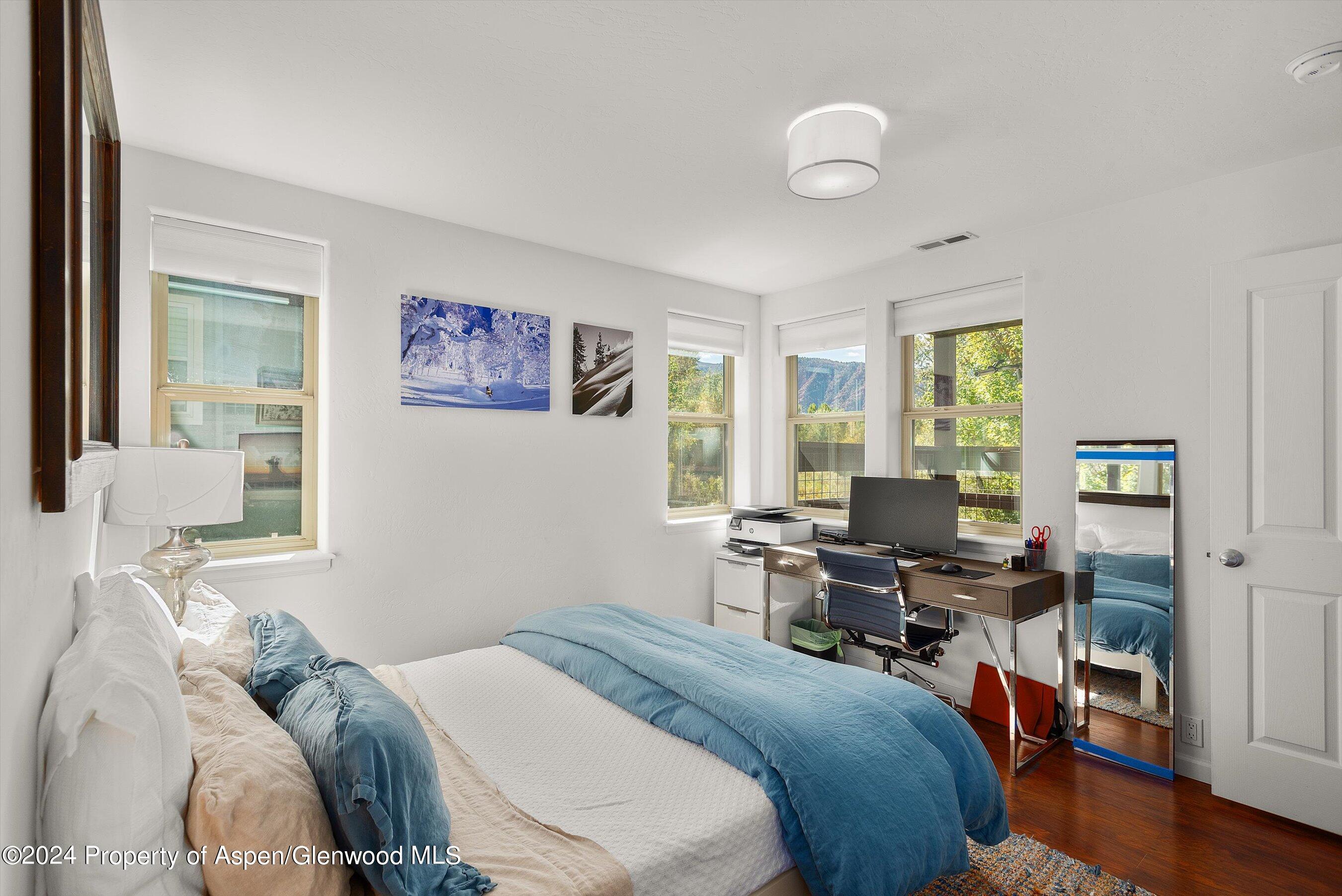 214 Lakeside Drive Basalt, CO 81621 - Photo 20 of 31 a bedroom with a bed and wooden floor