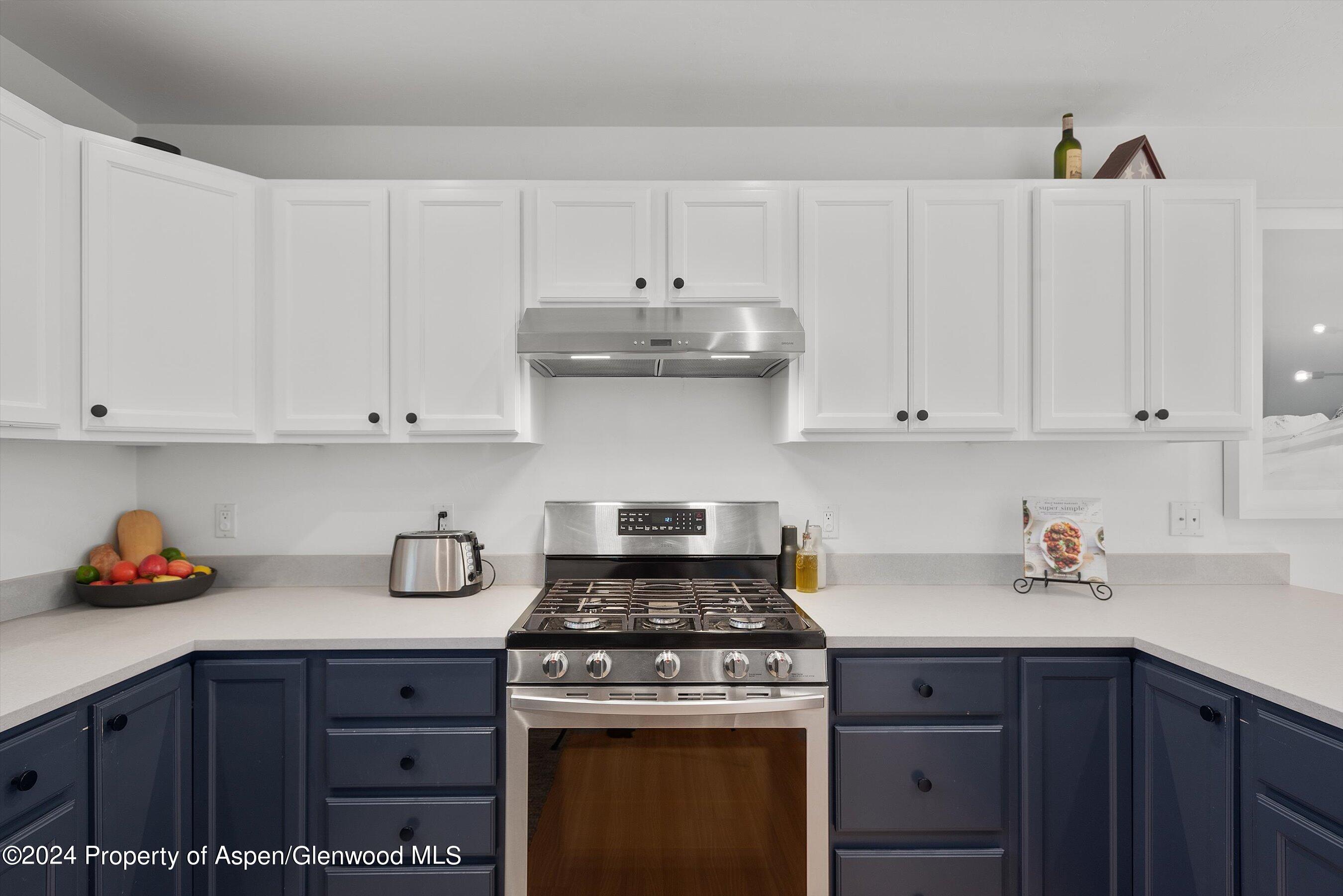 214 Lakeside Drive Basalt, CO 81621 - Photo 4 of 31 a kitchen with white cabinets and appliances