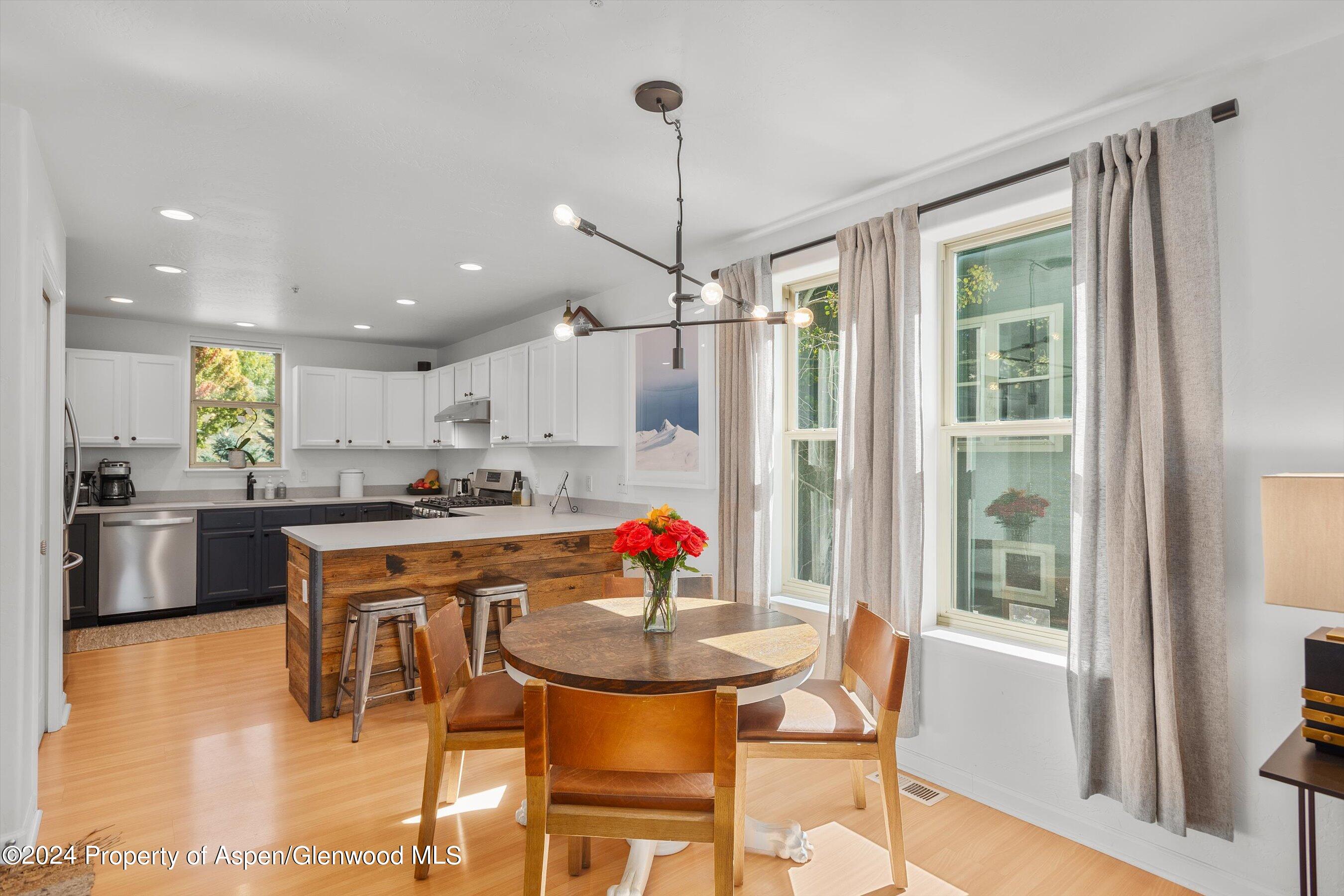 214 Lakeside Drive Basalt, CO 81621 - Photo 8 of 31 a kitchen with stainless steel appliances granite countertop a stove a refrigerator a kitchen island with a dining table and chairs