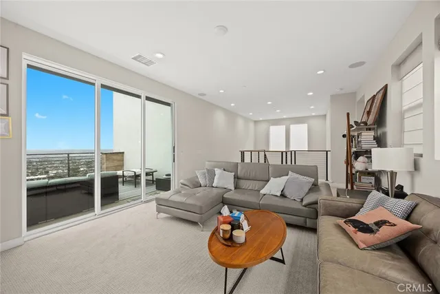 a view of a patio with couches table and chairs under an umbrella with a fire pit