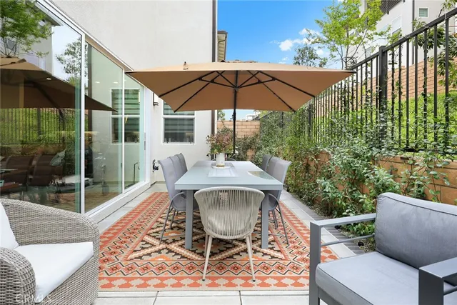 a view of the patio with dining table and chairs under an umbrella