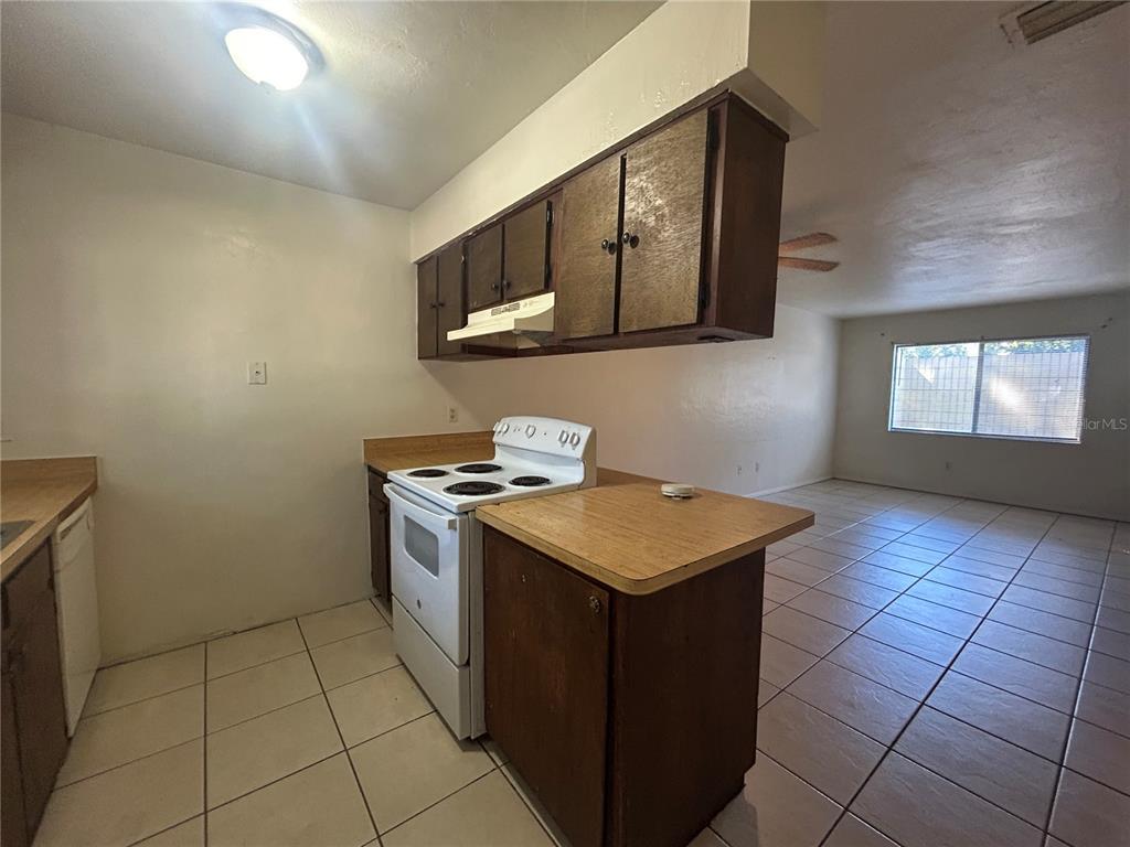 707 Southwest 68th Terrace, Unit B Gainesville, FL 32607 - Photo 5 of 12 a kitchen with stainless steel appliances granite countertop a stove a sink and a microwave