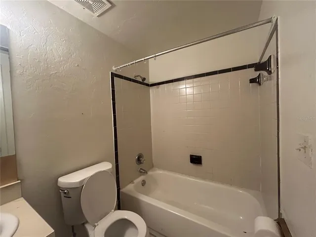 a bathroom with a shower a toilet and a bathtub