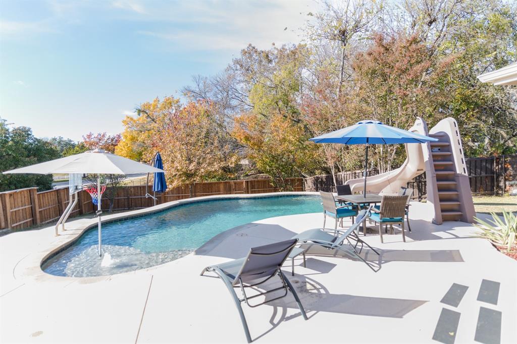 2107 Lacebark Lane Rockwall, TX 75087 - Photo 20 of 34 a view of a patio with a table and chairs under an umbrella
