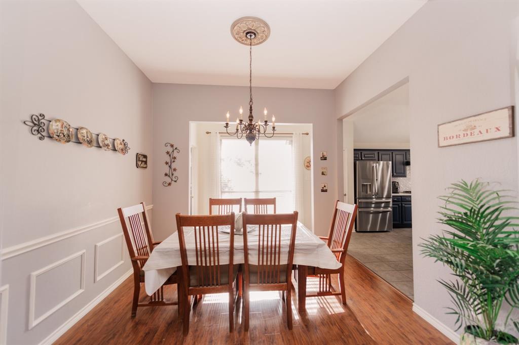 2107 Lacebark Lane Rockwall, TX 75087 - Photo 5 of 34 a dining room with furniture a chandelier and wooden floor