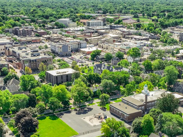 an aerial view of residential houses with outdoor space and trees