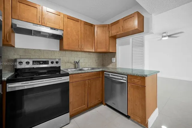a kitchen with stainless steel appliances granite countertop a stove and a microwave