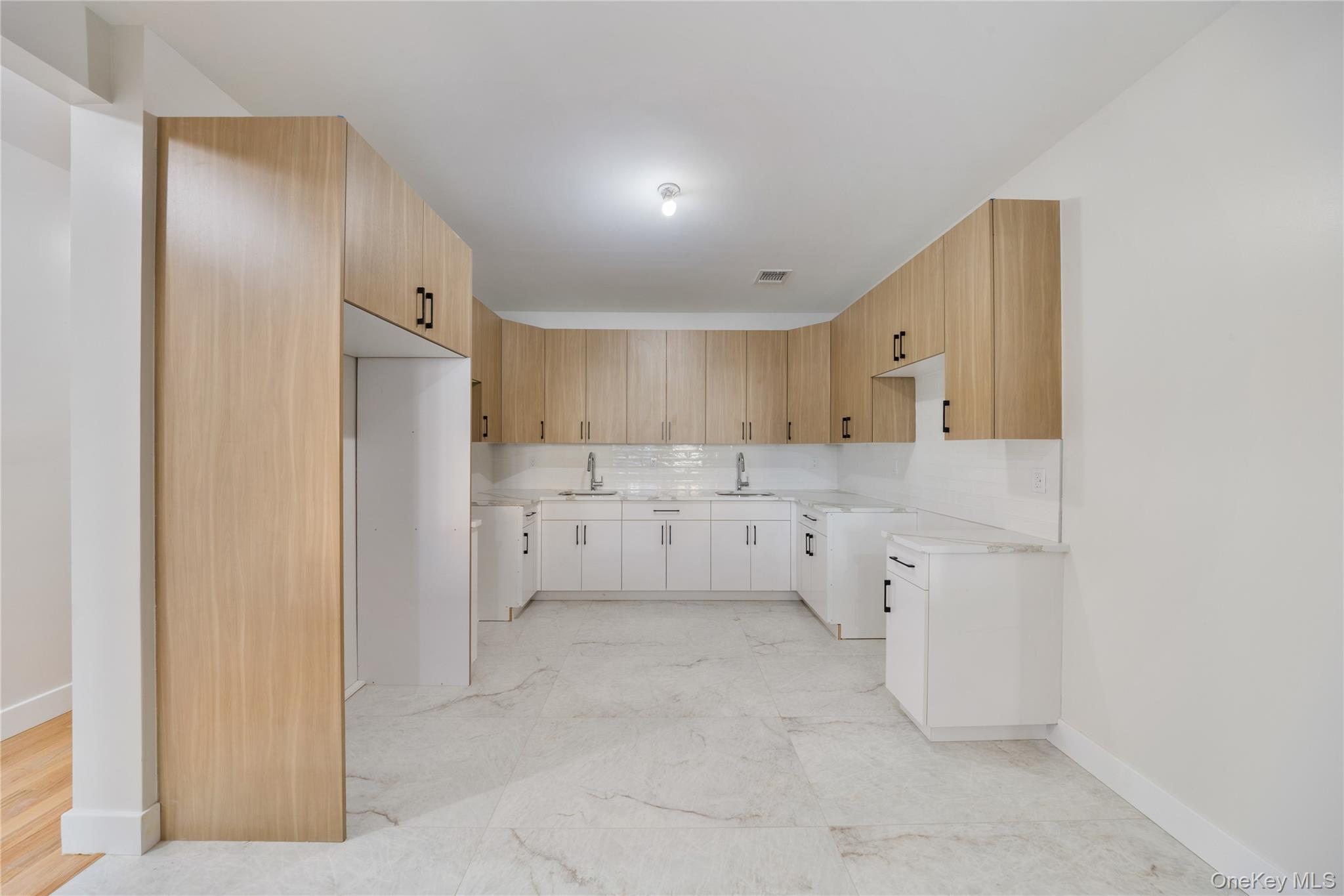 17 Lazer Court, Unit 102 Spring Valley, NY 10977 - Photo 15 of 31 Kitchen with tasteful backsplash, modern cabinets, light stone counters, and white cabinets