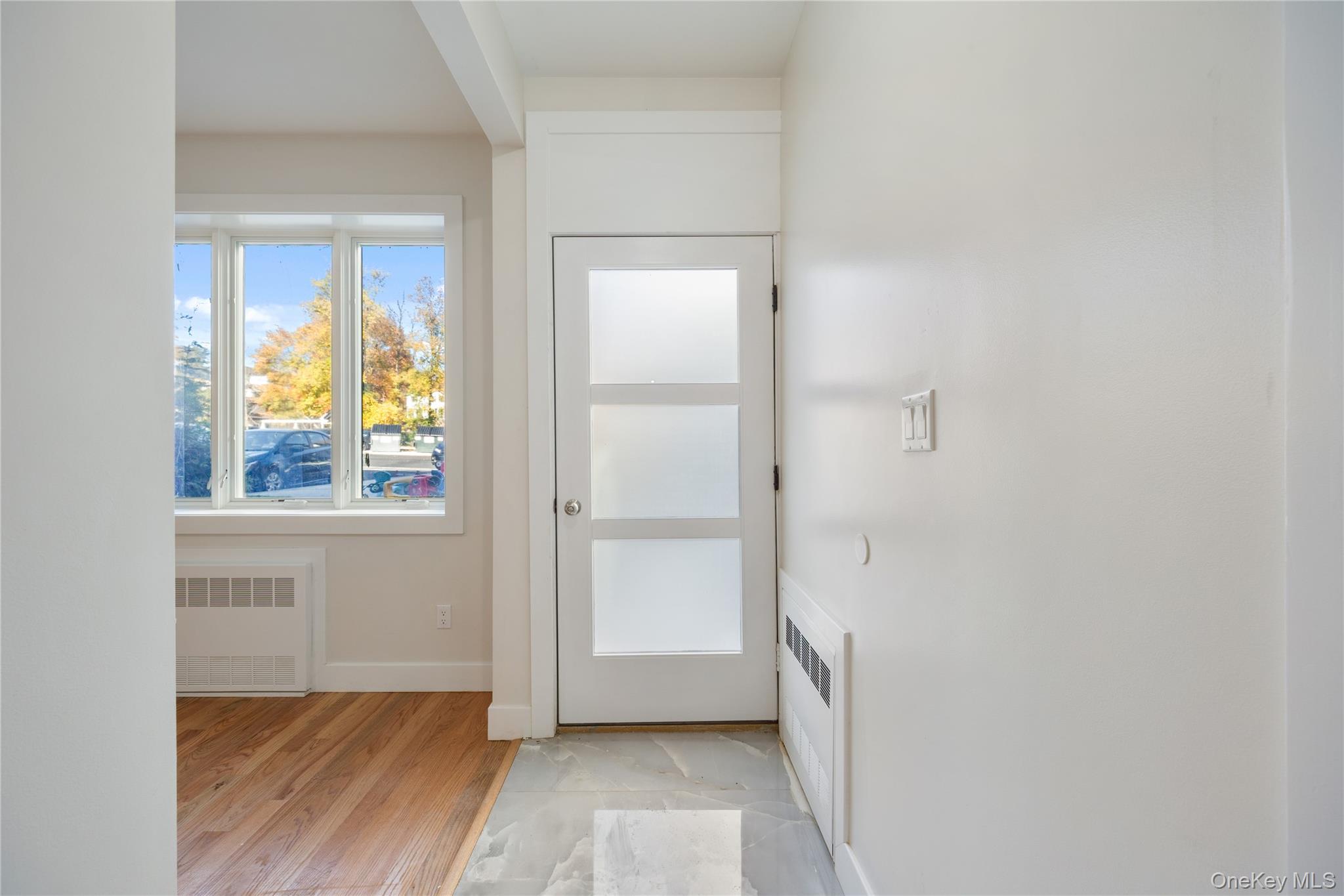 17 Lazer Court, Unit 102 Spring Valley, NY 10977 - Photo 6 of 31 Entryway featuring radiator heating unit and wood finished floors