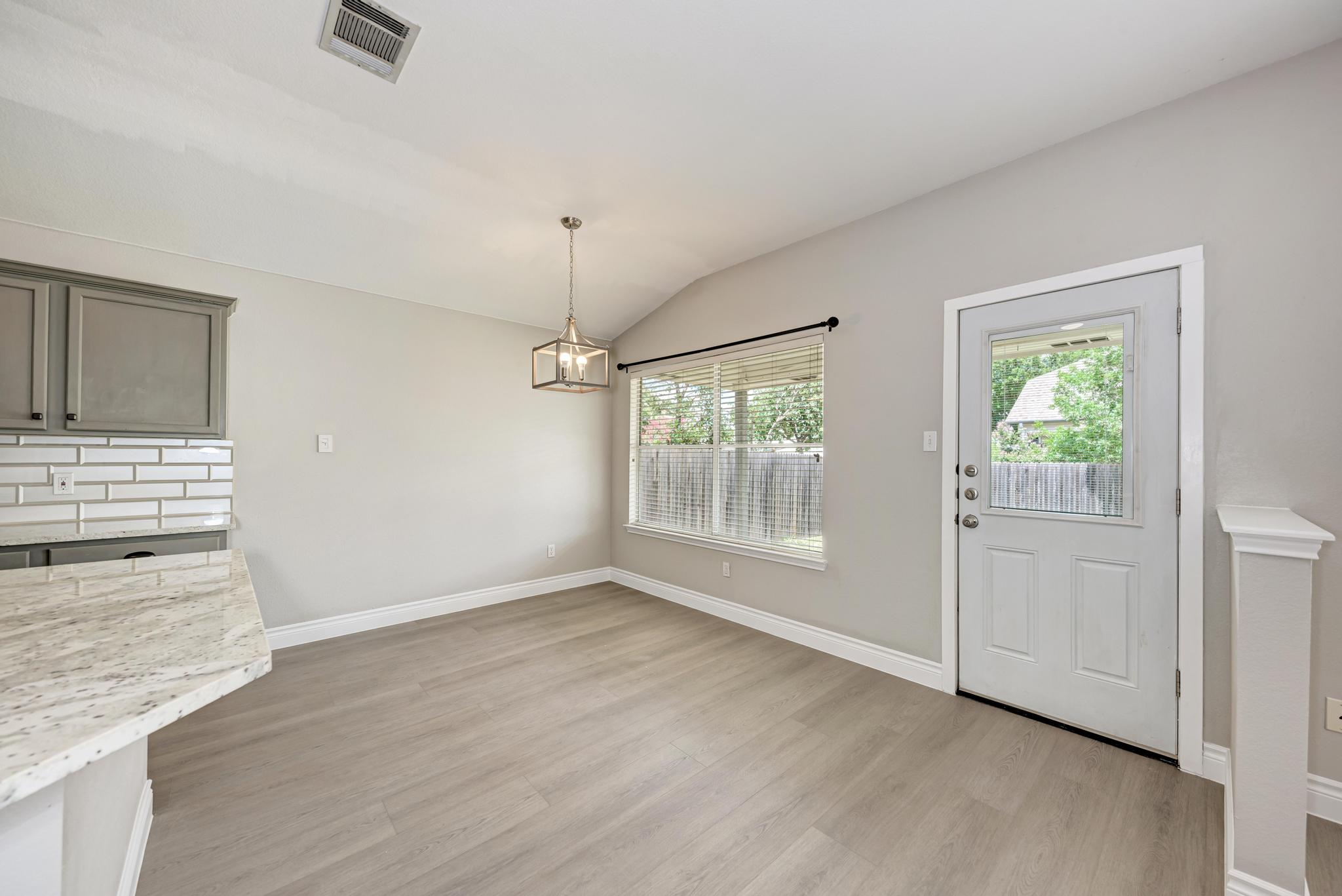 4408 Tello Path Austin, TX 78749 - Photo 12 of 38 Unfurnished dining area featuring light wood-type flooring, lofted ceiling, and a chandelier