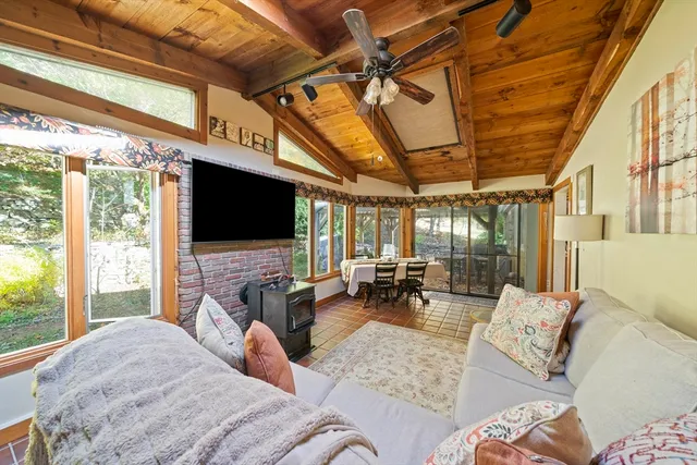 a living room with furniture a flat screen tv and a floor to ceiling window