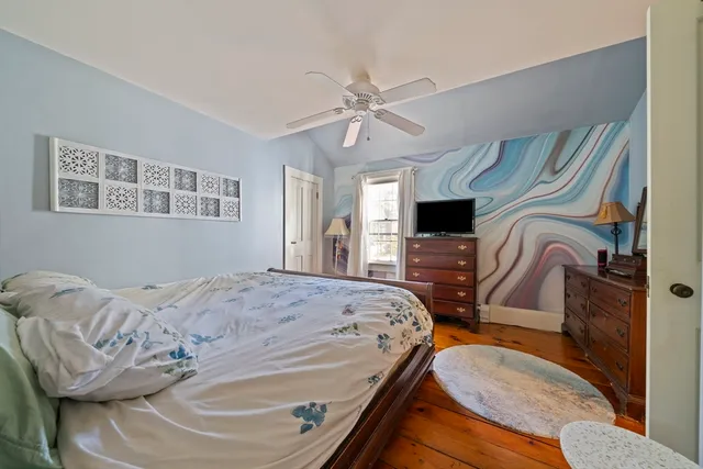 a bedroom with a bed flat screen tv and windows