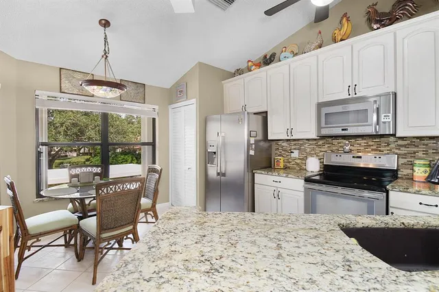 a kitchen with sink refrigerator and cabinets