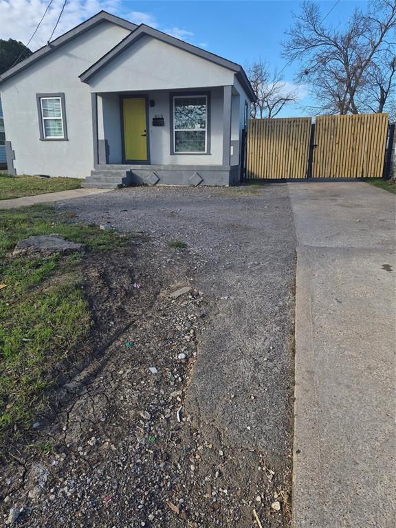 View of front of property with driveway, stucco siding, and a porch