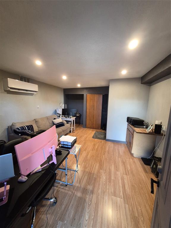 815 Bonnie View Road Dallas, TX 75203 - Photo 23 of 29 Living area featuring light wood finished floors, a wall mounted air conditioner, and recessed lighting