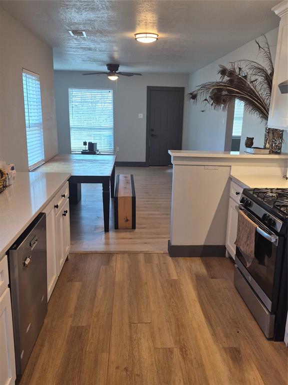 815 Bonnie View Road Dallas, TX 75203 - Photo 7 of 29 Kitchen with white cabinets, gas stove, stainless steel dishwasher, and light wood-type flooring