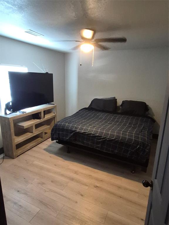 815 Bonnie View Road Dallas, TX 75203 - Photo 9 of 29 Bedroom with ceiling fan, light wood-type flooring, and a textured ceiling