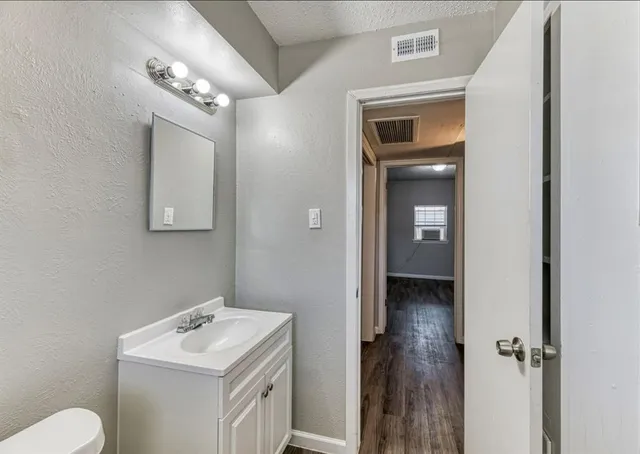 a bathroom with a toilet sink and mirror