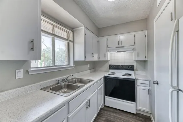 a kitchen with a stove sink and refrigerator