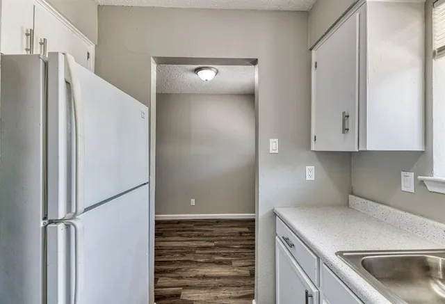 a kitchen with a refrigerator and cabinets