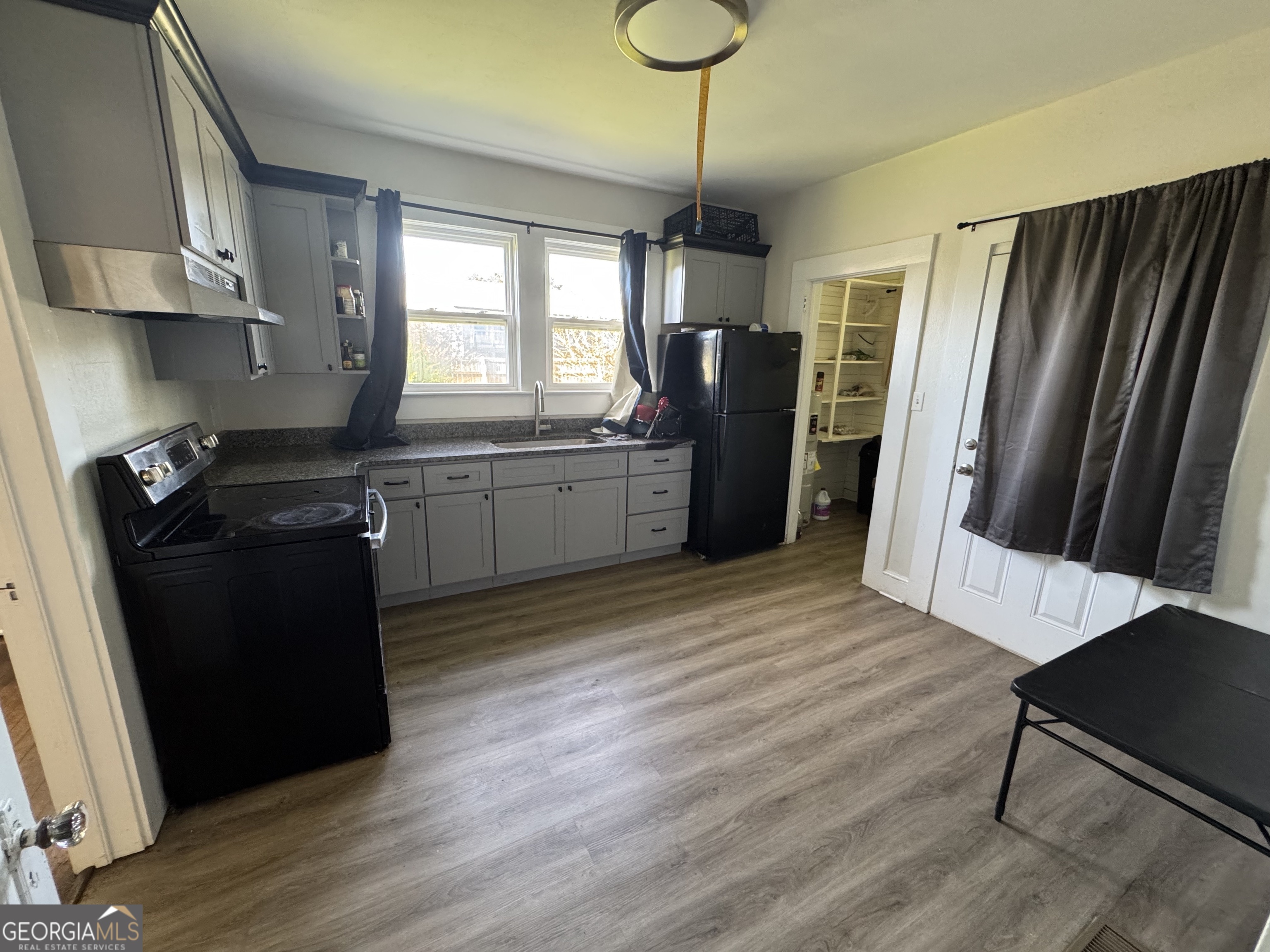 968 Elbert Street Elberton, GA 30635 - Photo 9 of 10 a kitchen with stainless steel appliances granite countertop a refrigerator a sink dishwasher a stove and white cabinets with wooden floor