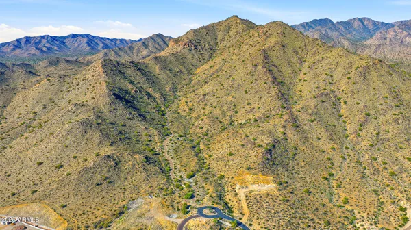 a view of a dry yard with mountains in the background