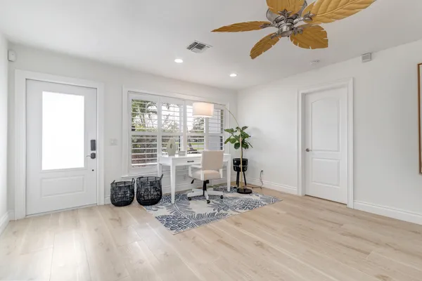 a living room with furniture and potted plants