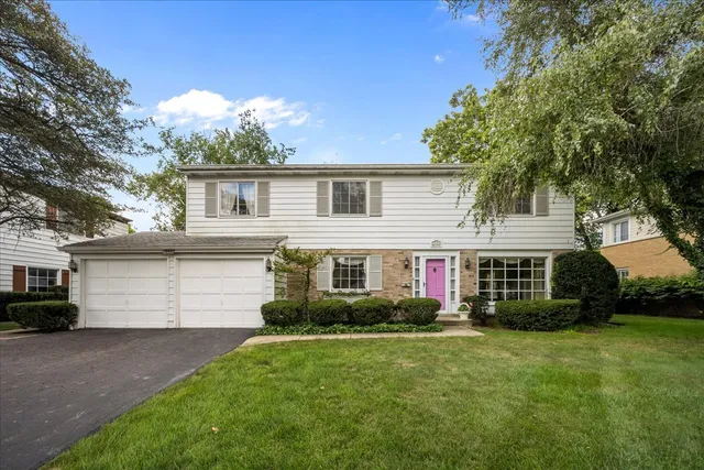 a front view of a house with a garden and plants