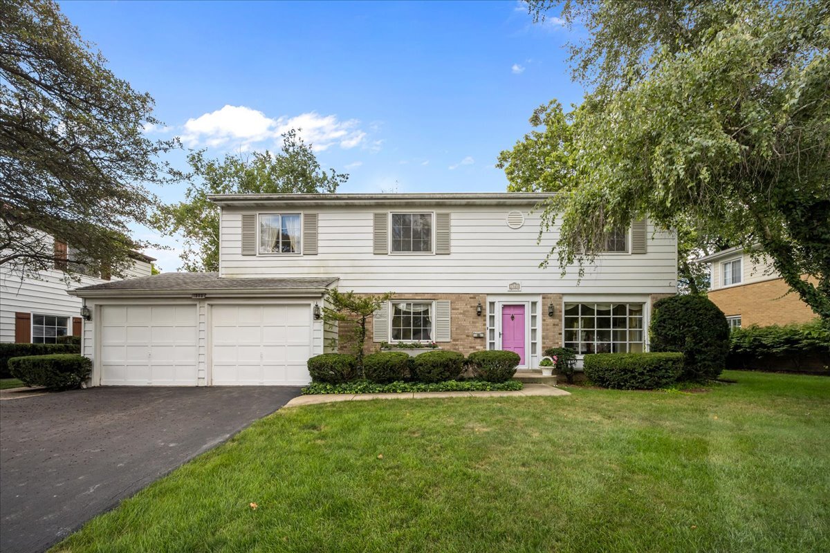 a front view of a house with a garden and plants