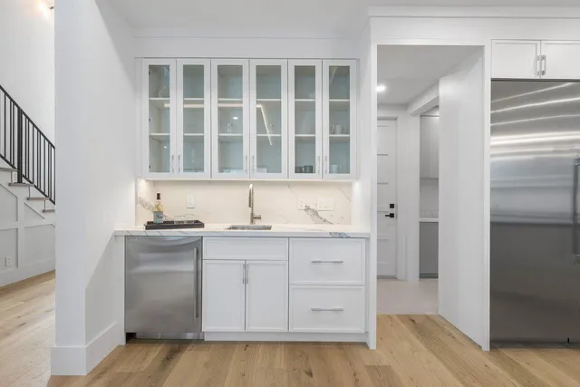 a kitchen with a dining table chairs and white cabinets