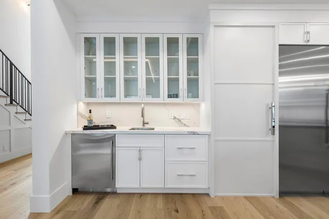 a kitchen with kitchen island granite countertop a sink a counter top space stainless steel appliances and cabinets