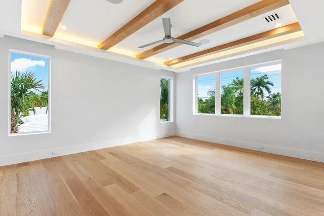 an empty room with a window and a ceiling fan