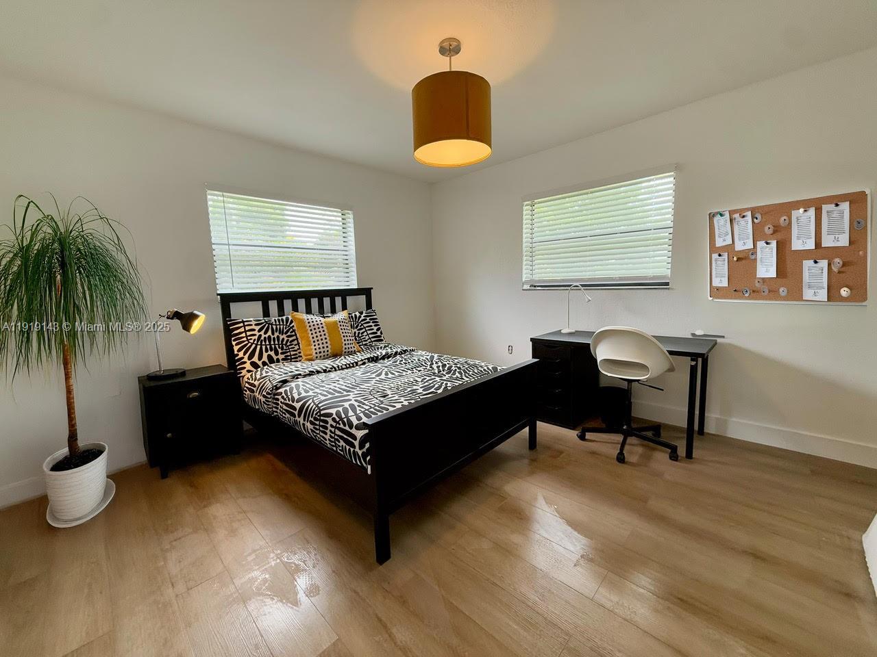 6250 Southwest 58th Place, Unit 1 South Miami, FL 33143 - Photo 12 of 13 a bedroom with a bed and a chandelier