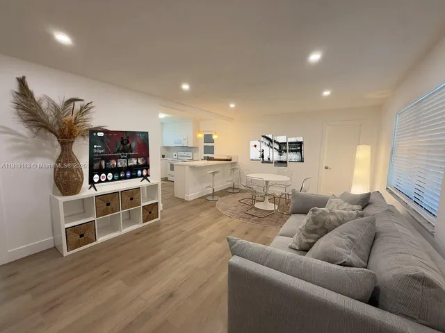 a living room with furniture and view of kitchen