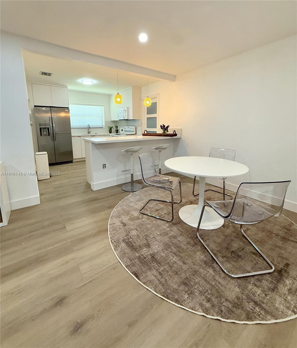 6250 Southwest 58th Place, Unit 1 South Miami, FL 33143 - Photo 4 of 13 a kitchen with stainless steel appliances kitchen island granite countertop a sink and cabinets