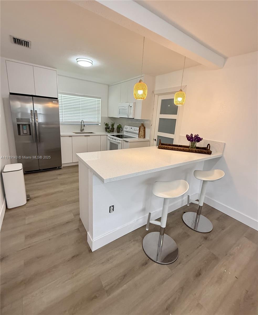 6250 Southwest 58th Place, Unit 1 South Miami, FL 33143 - Photo 5 of 13 a large kitchen with kitchen island a sink stainless steel appliances and cabinets
