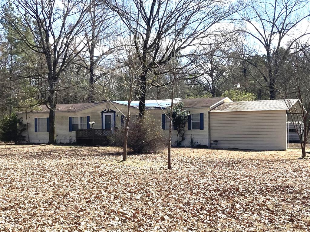 9515 Caddo Lake Road Mooringsport, LA 71060 - Photo 1 of 12 a front view of a house with a yard covered in snow