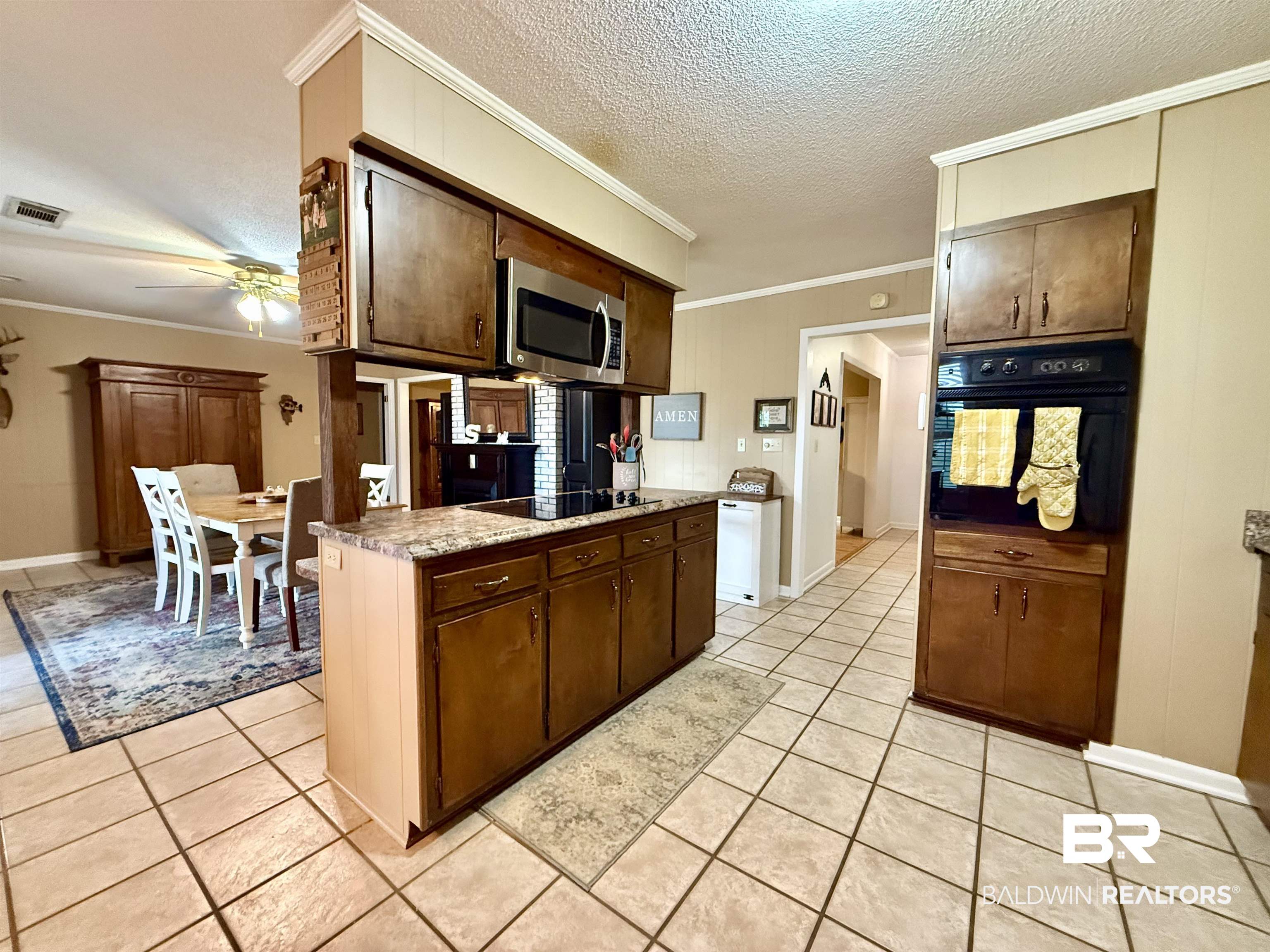 5971 Appleton Road Brewton, AL 36426 - Photo 8 of 23 Kitchen with black appliances, crown molding, a ceiling fan, light tile patterned flooring, and dark brown cabinets