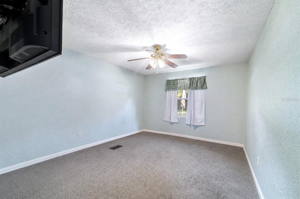 15755 Southwest 90th Avenue Dunnellon, FL 34432 - Photo 26 of 55 an empty room with windows and fan
