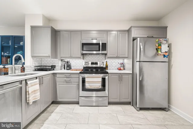 a kitchen with a refrigerator a sink and a stove top oven