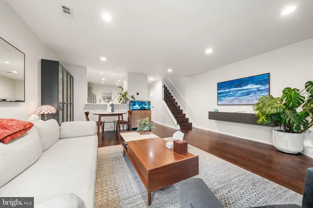 a living room with furniture kitchen view and a potted plant