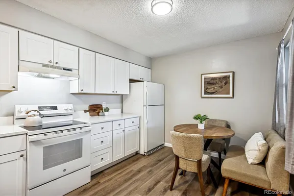 a kitchen with stainless steel appliances cabinets a dining table and chairs