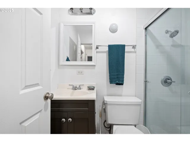 a bathroom with a sink a toilet a mirror and shower