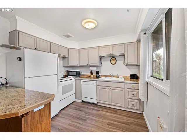 a kitchen with granite countertop white cabinets and white appliances