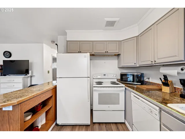 a kitchen with a sink a refrigerator and cabinets