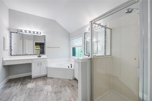 a large bathroom with a tub sink shower and mirror