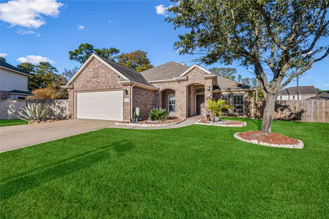a front view of a house with a yard and trees